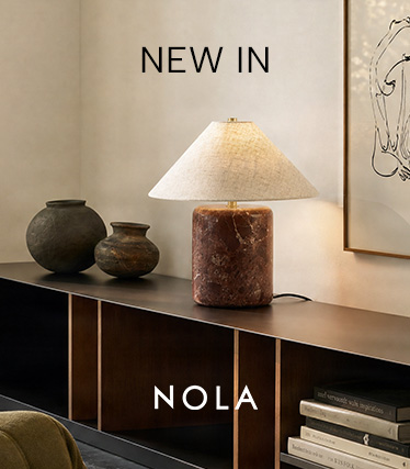 Stolna svjetiljka Nola s crvenkastosmeđim mramornim postoljem i stožastim lanenim sjenilom na tamnom ormariću. Tekst: „Novo – Nola“.