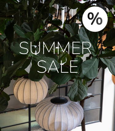 Viseće svjetiljke od tkanine na pozadini bujnog zelenila s oznakom Summer Sale.